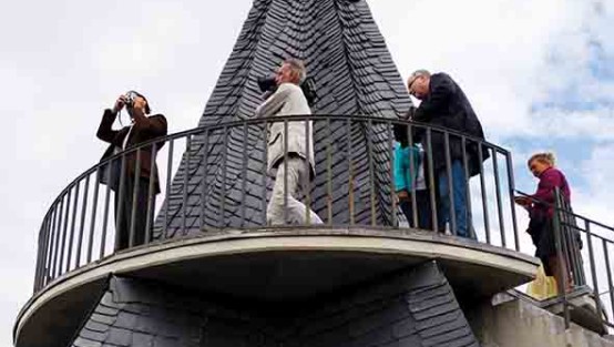 Drehteam und Schauspieler auf einer Aussichtsplattform eines Dachs.