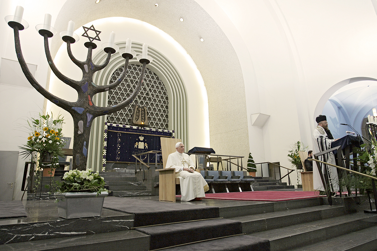 Der Papst sitzt in der Synagoge in Köln neben einem siebenarmigen Leuchter