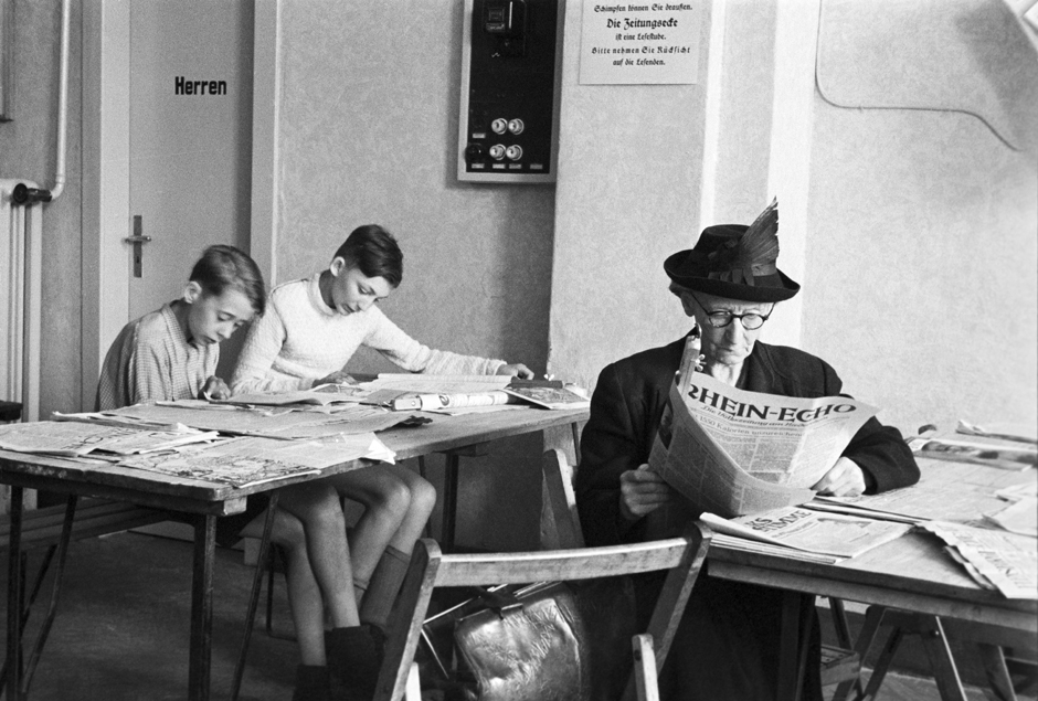 Drei Personen lesen Zeitung