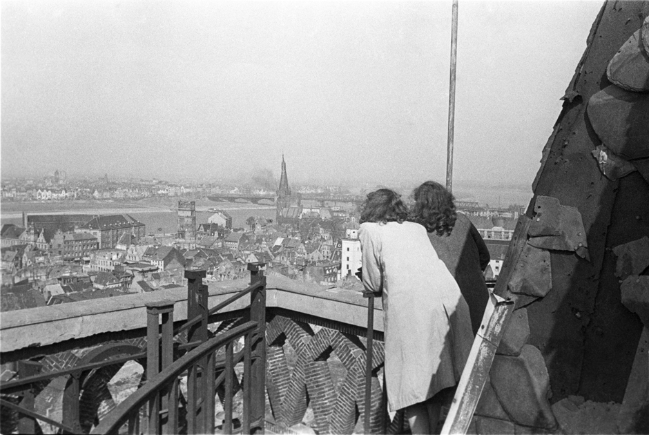 Zwei Frauen stehen auf einer Plattform und schauen auf die Stadt Düsseldorf
