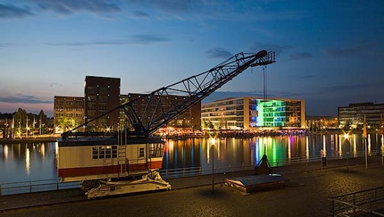 Historischer Hafenkran vor moderner Architekturkulisse im Duisburger Innenhafen