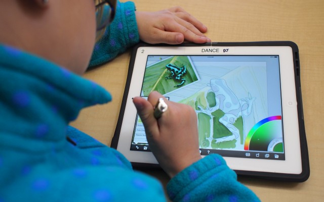 Foto: Brad Flickinger / flickr Blick über die Schulter eines Kindes im blauen Pullover auf ein Tablet: Es zeichnet einen Frosch.